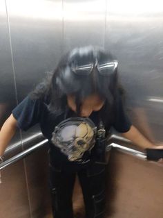 a woman with goggles on standing in an elevator