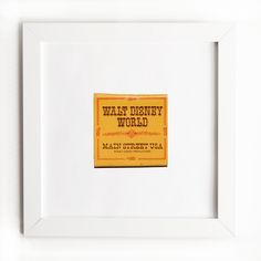 a yellow sign that is on the side of a white framed wall in front of a white frame