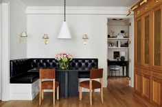 a dining room table with chairs and a black couch