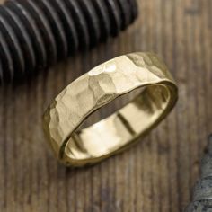 a silver ring sitting on top of a wooden table next to a screwdriver