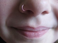 a close up of a child's nose with a pink nose ring