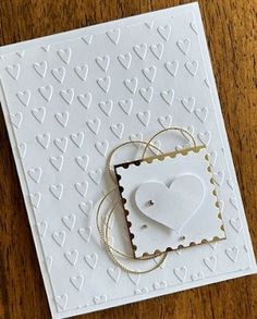 a close up of a card on a table with a stamp and some paper hearts