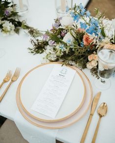 the table is set with flowers and silverware