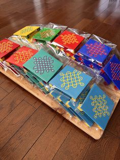 a wooden table topped with lots of different colored cards on top of plastic wrappers