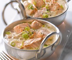 two silver pans filled with soup on top of a table