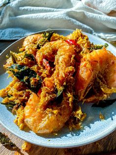 a white plate topped with fried food on top of a wooden table