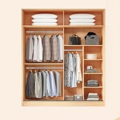 an open closet with clothes and other items on shelves, including folded shirts and pants