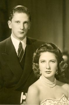 an old black and white photo of a man in a suit next to a woman