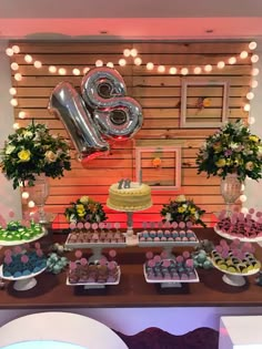 a table topped with lots of desserts and balloons