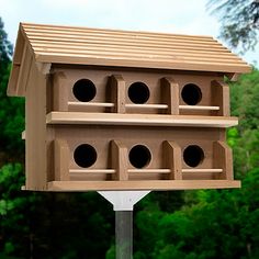 a wooden bird house on top of a metal pole