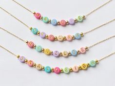 Our Bright Colorful Beads Name Necklace for Kids/Girls is custom made with dainty colorful letter beads and 18K plated gold spacer beads.  This eye-catching necklace with its colorful hued beads will match so many outfits. These necklaces would make great party favors for a child's Birthday party, Christmas Stocking Stuffers, or Birthday Gifts for girls. Beads are chosen randomly and the necklace is accented with 18k gold round ball beads.  Necklace chain is 18k gold plated and dainty.   Necklac Cheap Personalized Beaded Necklaces For Birthday, Cute Beaded Necklace With Letter Beads For Birthday, Cute Multicolor Beaded Necklaces For Birthday, Cute Multicolor Beaded Necklaces For Gifts, Cute Multicolor Beaded Necklace For Gift, Cute Multicolor Beaded Necklace As Gift, Playful Beaded Necklace With Letter Beads For Gift, Cute Beaded Necklace With Letter Beads For Gift, Cute Beaded Necklaces With Letter Beads For Gift