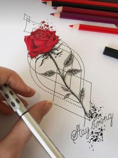 someone is drawing a rose on paper with pencils