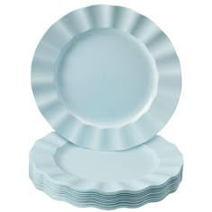 white plates stacked on top of each other in the shape of an ocean wave, set against a white background