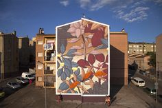 a mural on the side of a building with flowers painted on it's sides