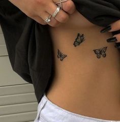 a woman's stomach with butterfly tattoos on her side and the word love written in black ink