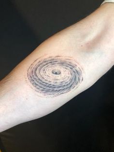 a man's arm with a tattoo on it that looks like a spiral design