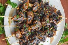 skewered meat and vegetables on a plate with parsley garnishes