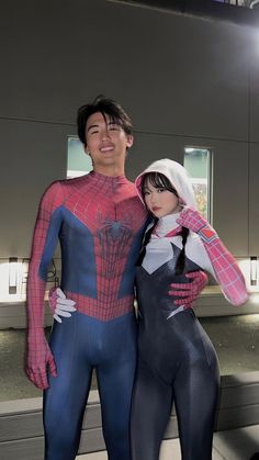 a man and woman in spider - man costumes posing for a photo with their arms around each other