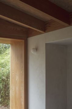 an open window in the corner of a room with wood trimming on the walls