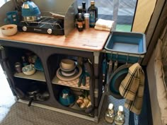 a kitchen area with dishes, cups and utensils on the counter next to an rv door