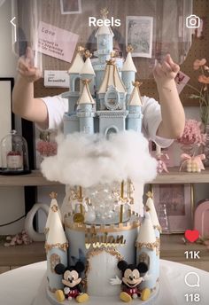 there is a cake made to look like a castle with mickey and minnie mouse on it