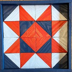 an orange, white and blue pattern is in a wooden frame