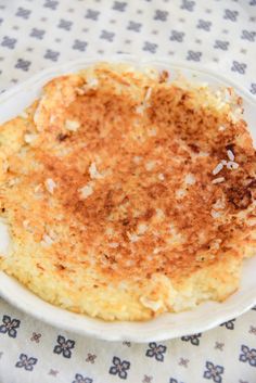 a white plate topped with hash browns on top of a blue and white table cloth