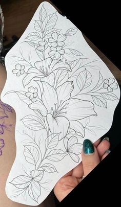 a woman's arm with flowers drawn on it and a tattoo design on the side