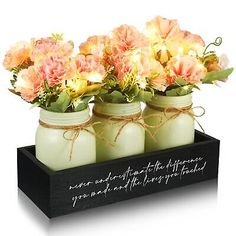 three mason jars with flowers in them on a tray