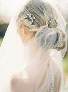 a woman wearing a veil with flowers in her hair