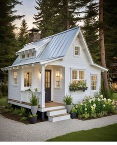 a small white house with a porch and steps leading to the front door