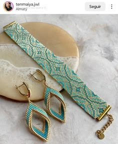 a pair of blue and gold beaded bracelets with matching earrings on a plate