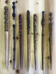 several different types of carved wooden objects on a wood surface, including canes and knives