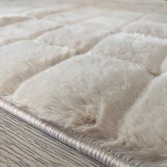 a close up view of an unmade bed with white fur on the top and bottom