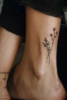 a woman's foot with a small flower tattoo on the side of her leg