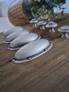 four silver spoons sitting on top of a wooden table