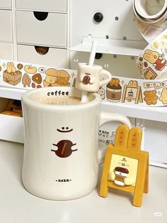 a coffee mug sitting on top of a counter next to a cup holder with a spoon in it