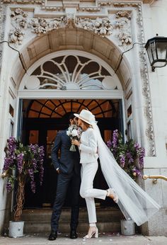 a bride and groom standing on the steps of a building