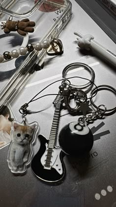 an assortment of items on a table including a guitar, keychain and cat