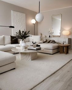 a living room filled with white furniture and pillows on top of a carpeted floor