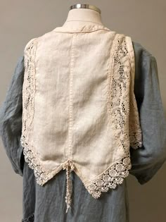 the back of a woman's blouse with lace trimmings and buttons on it