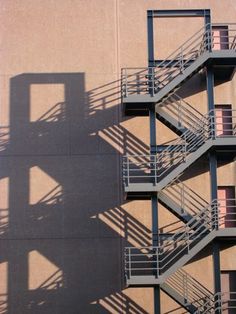 the shadow of a fire escape on a building