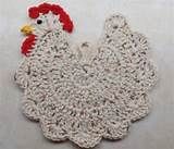 a crocheted chicken sitting on top of a white table next to a red and yellow object