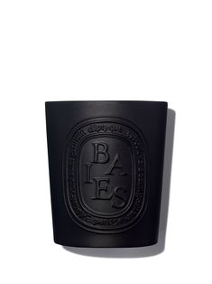 a black candle sitting on top of a white surface with the words baks written in it