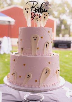 a three tiered cake with ghost decorations on it