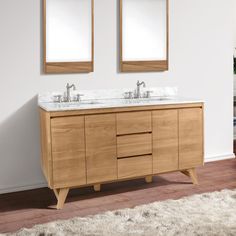 a bathroom with two sinks and mirrors on the wall next to a rug in front of it