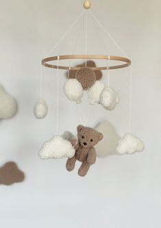 there is a teddy bear hanging from the ceiling with clouds in front of it,