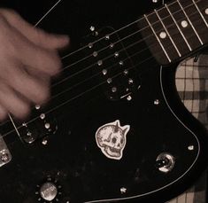 a person playing an electric guitar with a skull sticker on it