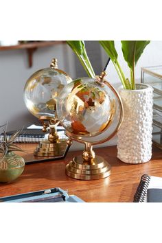 a desk topped with two glass globes filled with plants