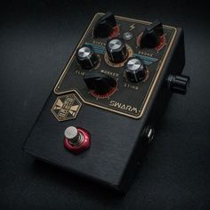 a close up of a black and red guitar pedal with knobs on the top